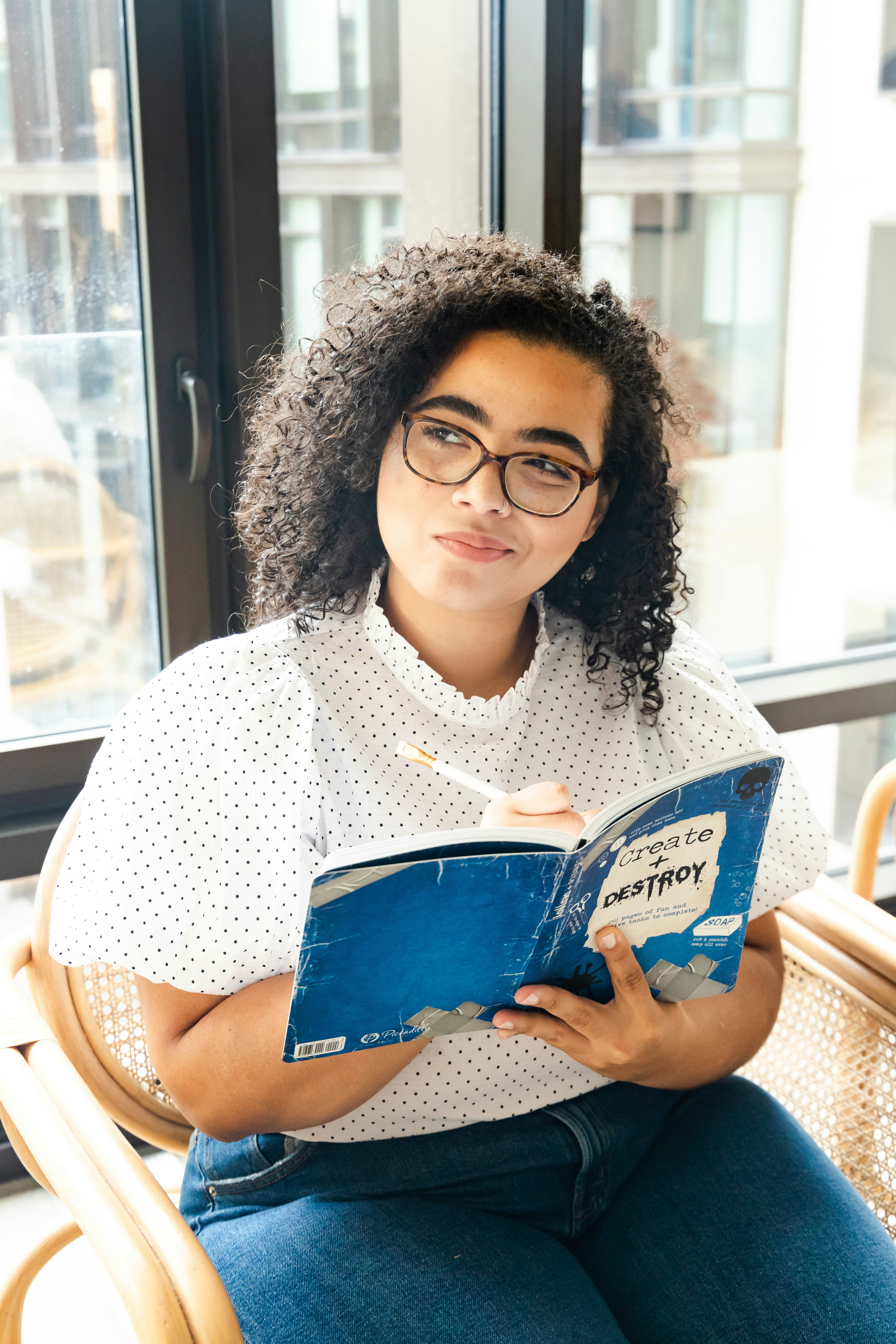 Woman with a curly hair holding a book